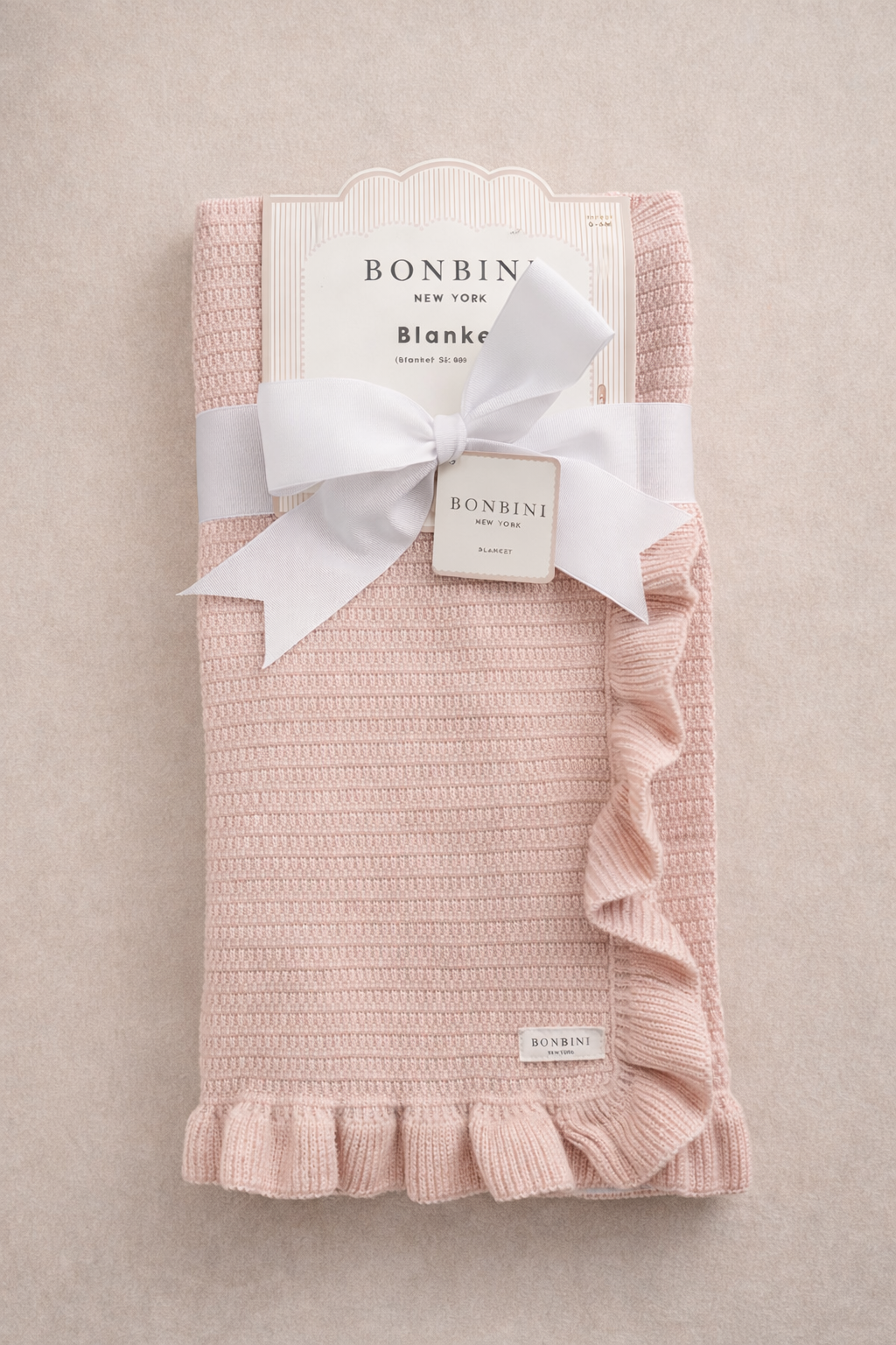Pink knitted baby receiving blanket folded with ribbon, soft newborn swaddle by Sielle & Sienna